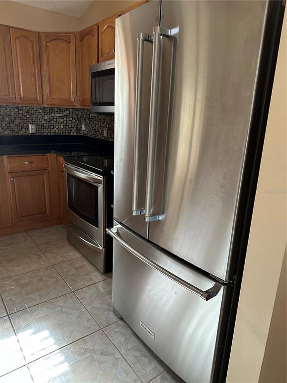 917 Camino Del Rey Drive Lady Lake, FL 32159 - Photo 16 of 46 a kitchen with granite countertop a refrigerator and a sink