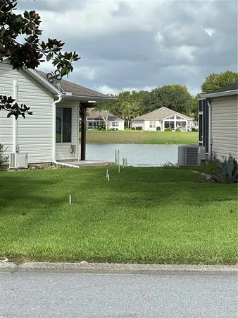 a view of a house with a big yard and potted plants