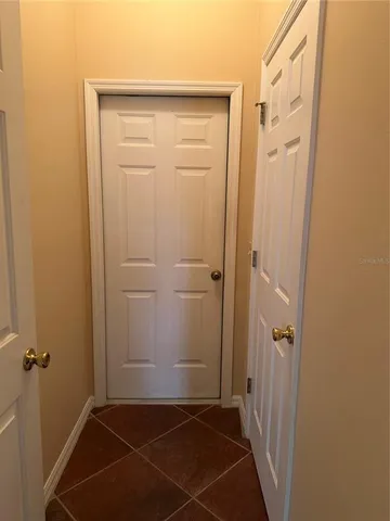 a view of a hallway with wooden floor and a bathroom
