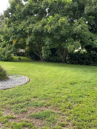 a view of an empty room with a window and kitchen view