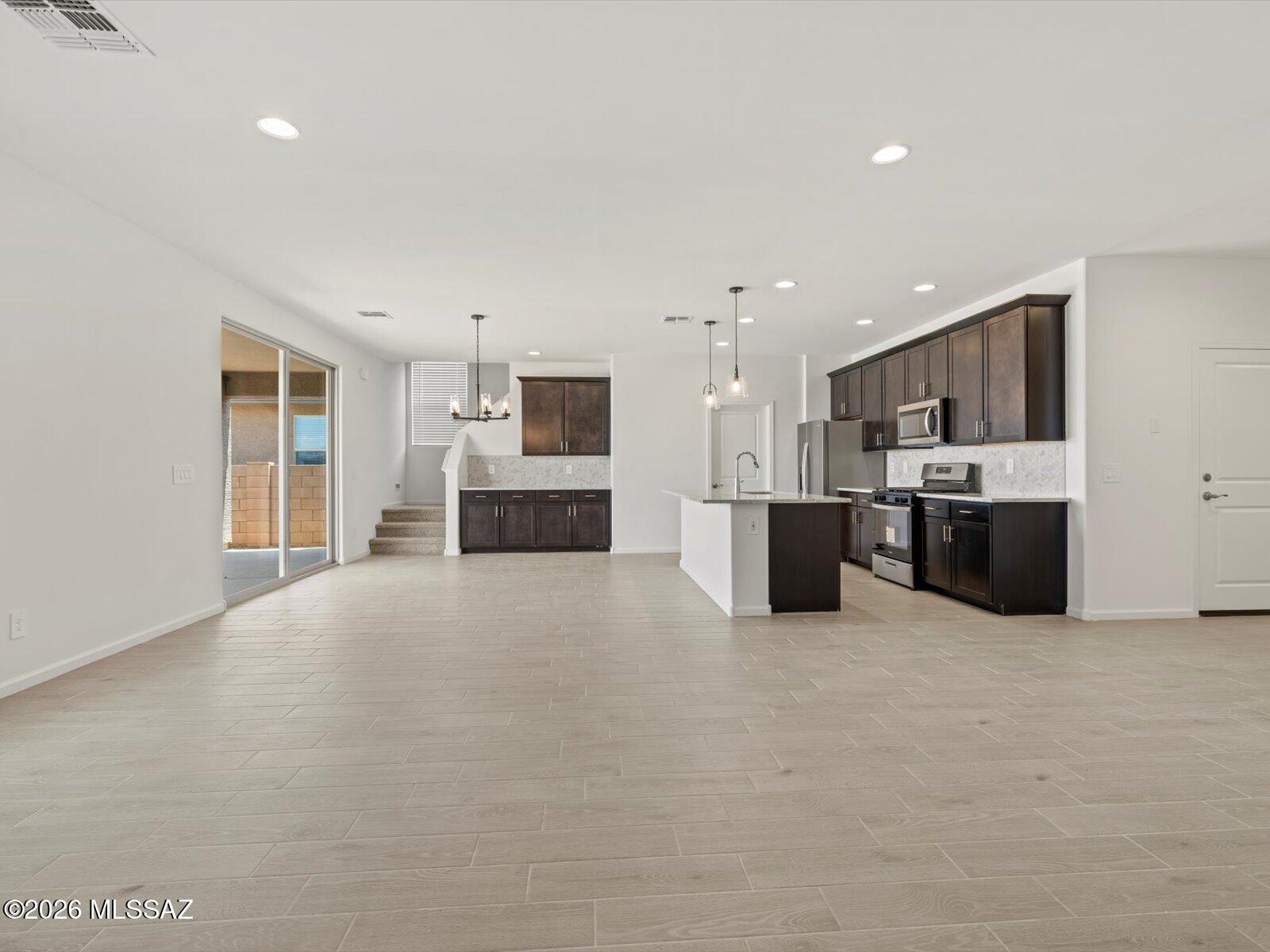 5133 West Gainer Ridge Road Tucson, AZ 85757 - Photo 6 of 16 a large white kitchen with a refrigerator a stove top oven and white cabinets