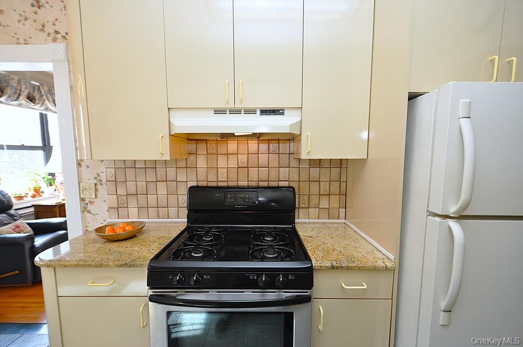 143 Garth Road, Unit 4D Scarsdale, NY 10583 - Photo 11 of 45 Updated eat-in-kitchen has granite counters, tile backsplash and a window for natural light and ventilation.