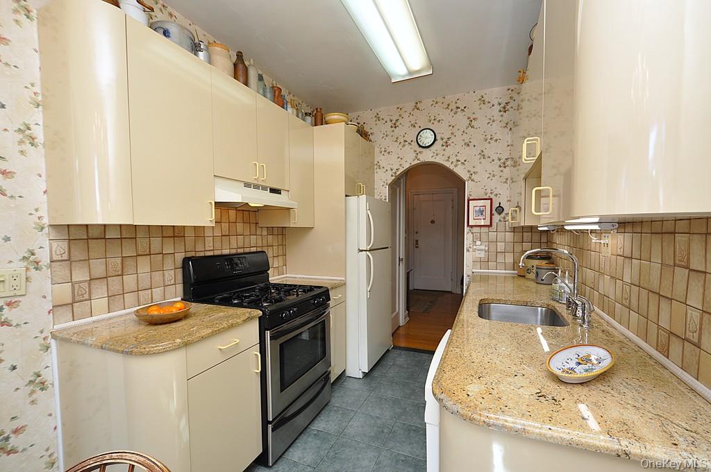 143 Garth Road, Unit 4D Scarsdale, NY 10583 - Photo 12 of 45 Updated eat-in-kitchen has granite counters, tile backsplash and a window for natural light and ventilation.