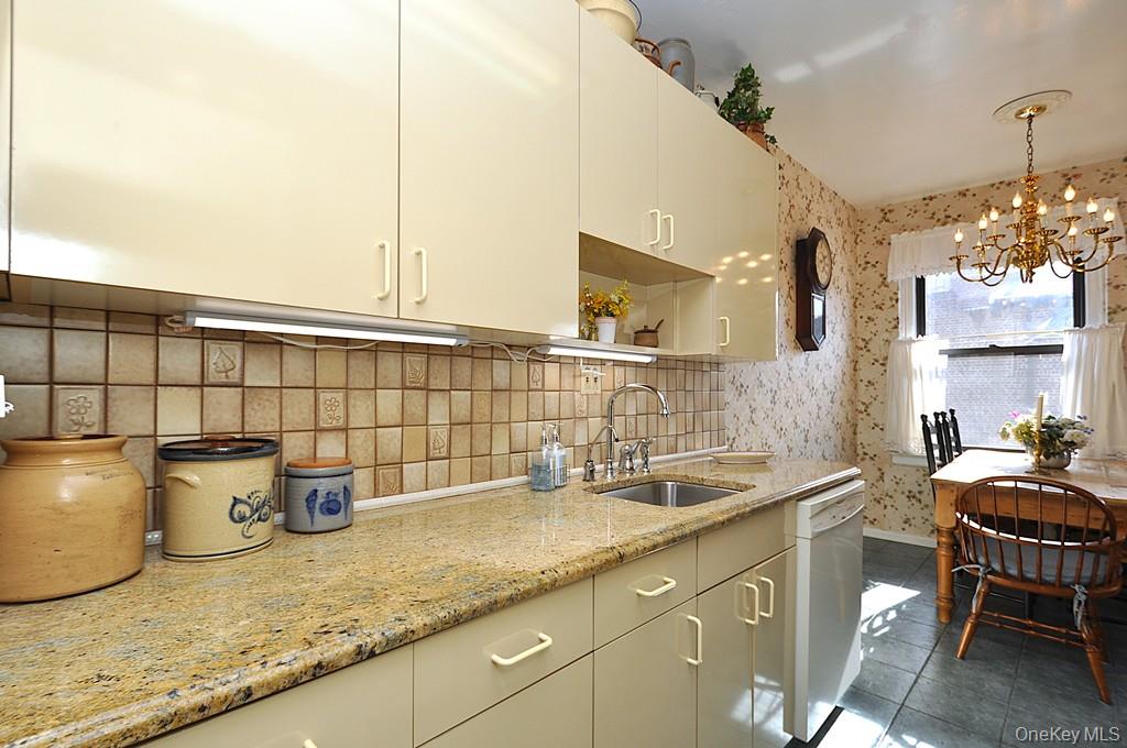 143 Garth Road, Unit 4D Scarsdale, NY 10583 - Photo 6 of 45 Updated eat-in-kitchen has granite counters, tile backsplash and a window for natural light and ventilation.