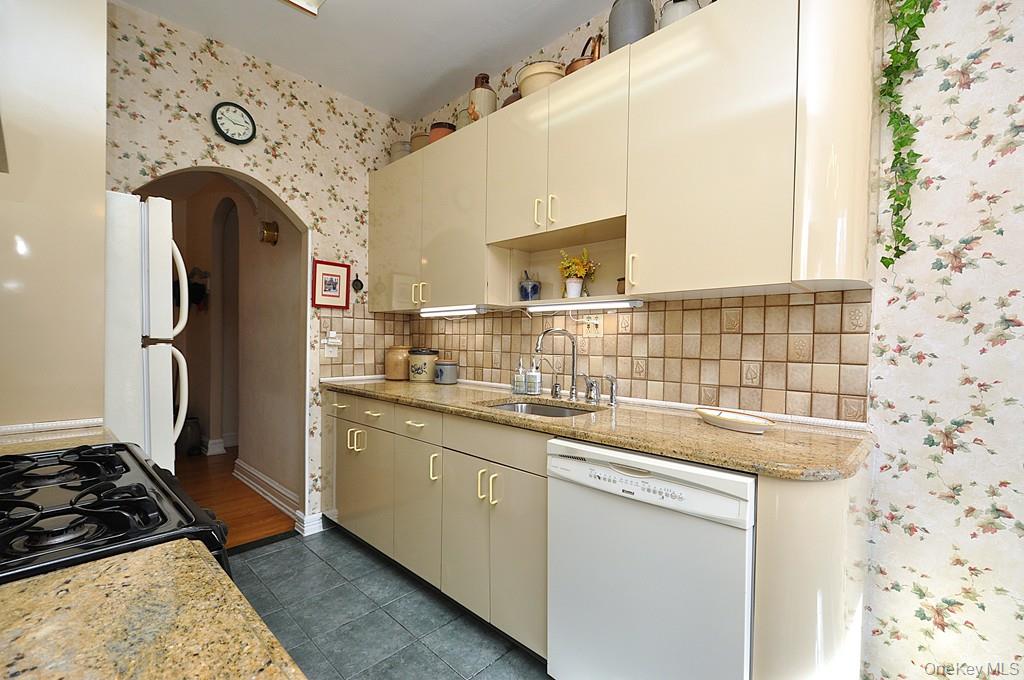143 Garth Road, Unit 4D Scarsdale, NY 10583 - Photo 7 of 45 Updated eat-in-kitchen has granite counters, tile backsplash and a window for natural light and ventilation.