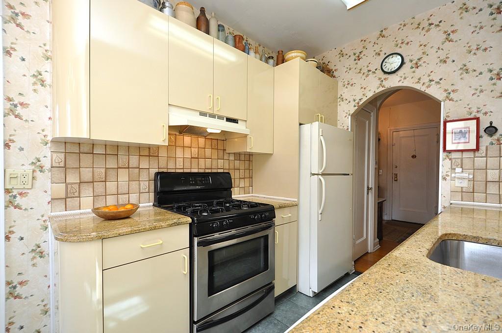 143 Garth Road, Unit 4D Scarsdale, NY 10583 - Photo 8 of 45 Updated eat-in-kitchen has granite counters, tile backsplash and a window for natural light and ventilation.