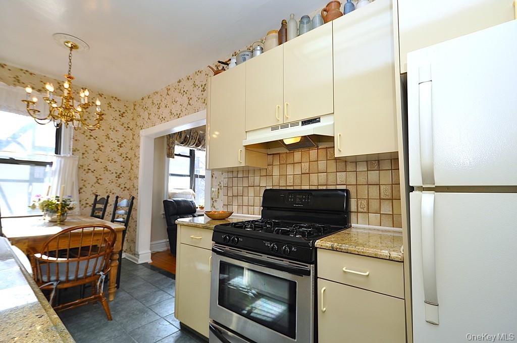 143 Garth Road, Unit 4D Scarsdale, NY 10583 - Photo 9 of 45 Updated eat-in-kitchen has granite counters, tile backsplash and a window for natural light and ventilation.