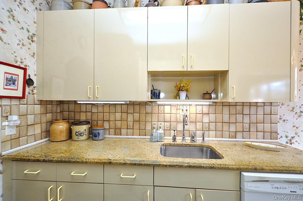 143 Garth Road, Unit 4D Scarsdale, NY 10583 - Photo 10 of 45 Updated eat-in-kitchen has granite counters, tile backsplash and a window for natural light and ventilation.