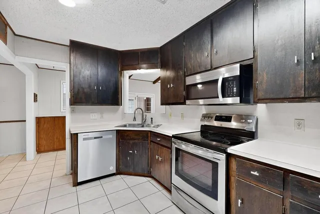 a kitchen with stainless steel appliances a stove sink microwave and cabinets