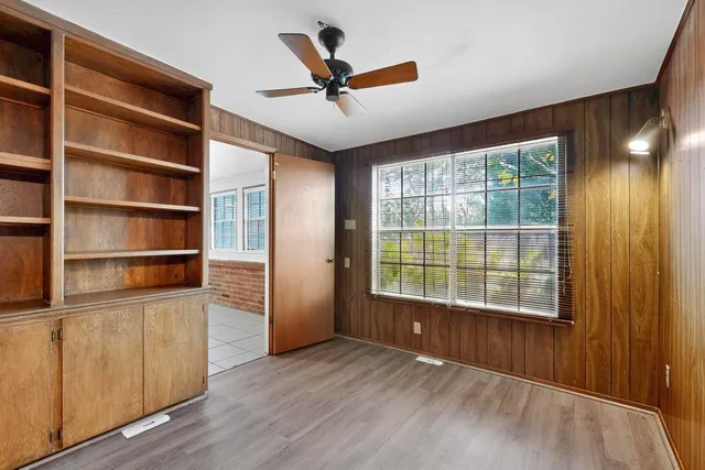 a view of an empty room with a window and wooden floor
