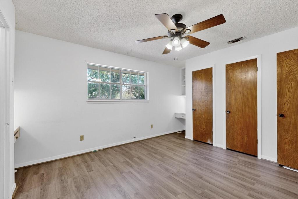 5180 Farm To Market Road 972 Granger, TX 76530 - Photo 28 of 39 a view of an empty room with wooden floor and a ceiling fan