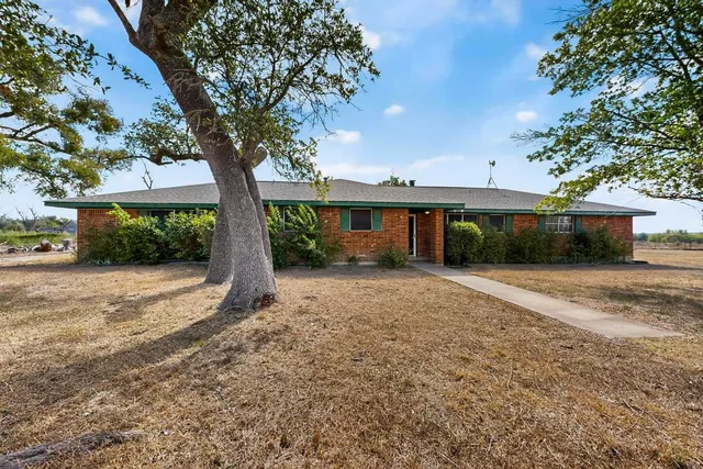 a view of a house with a yard and tree
