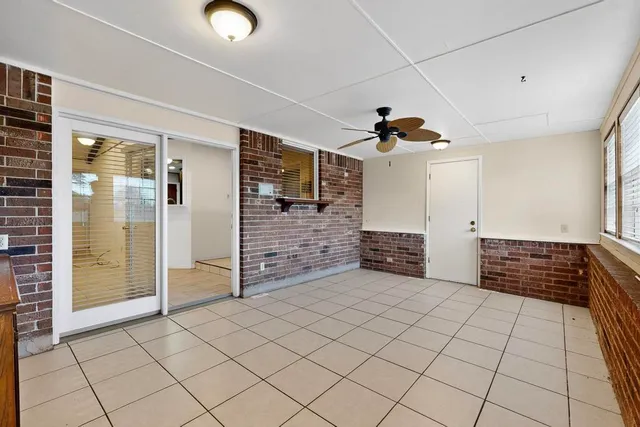 an empty room with windows and brick walls