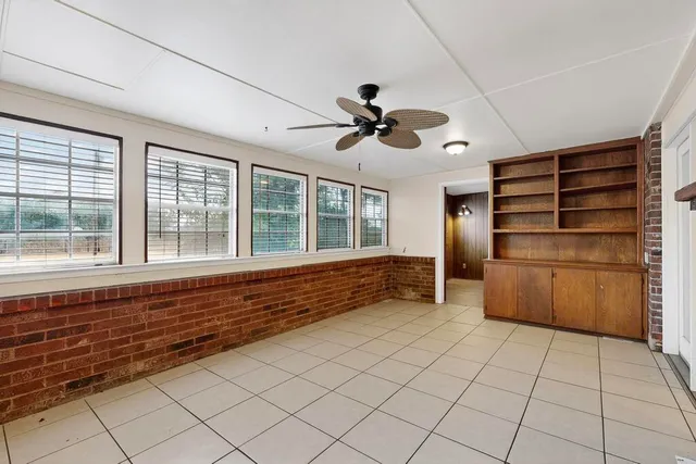 a view of empty room with windows and cabinet