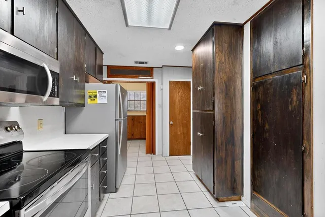 a kitchen with stainless steel appliances a refrigerator and a stove top oven