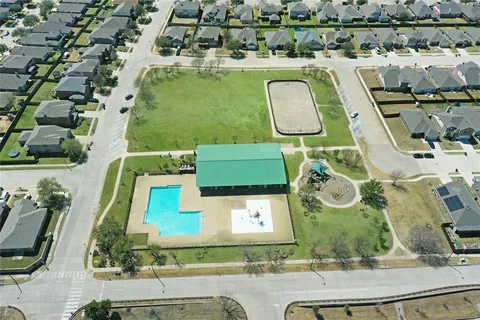 an aerial view of a swimming pool with outdoor seating