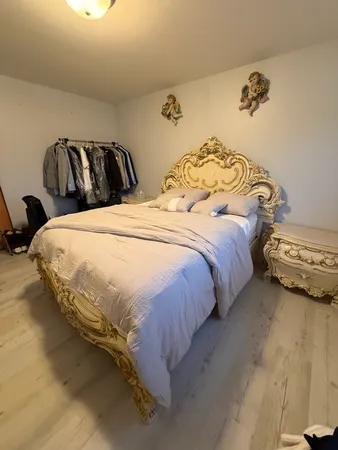 a bedroom with a bed and painting on the wall