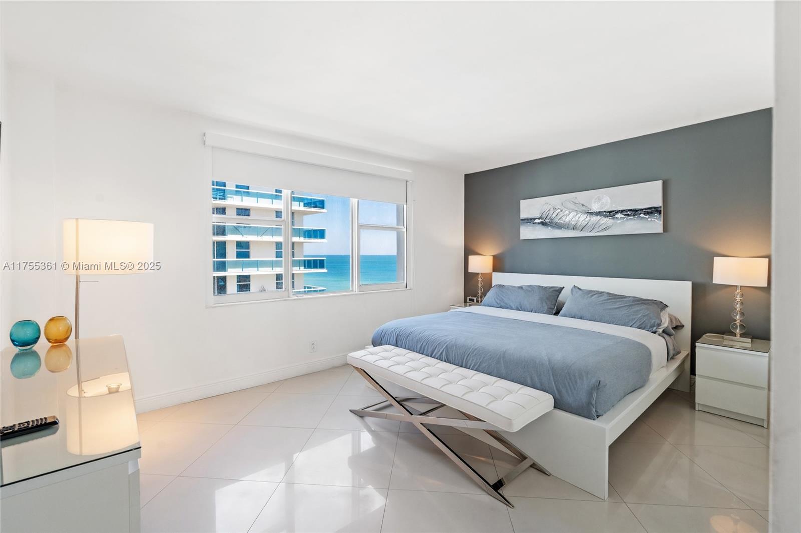 9195 Collins Avenue, Unit 1103 Surfside, FL 33154 - Photo 11 of 23 a spacious bedroom with a bed a couch and a window