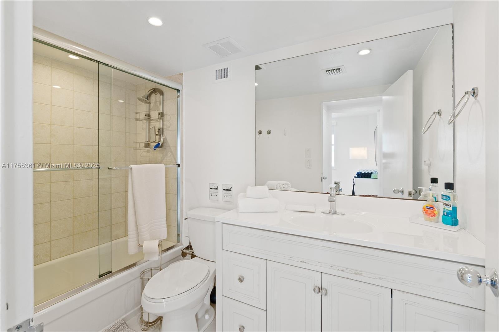 9195 Collins Avenue, Unit 1103 Surfside, FL 33154 - Photo 13 of 23 a bathroom with a shower sink vanity mirror and toilet