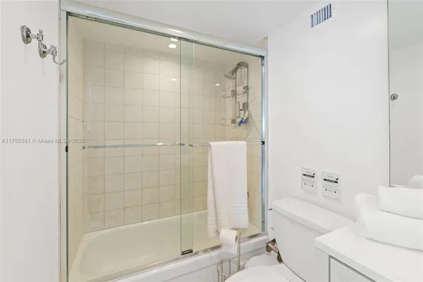 a bathroom with a bathtub shower and toilet