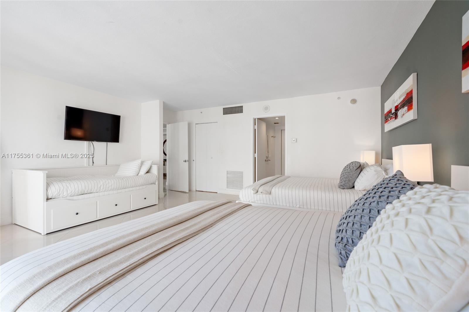 9195 Collins Avenue, Unit 1103 Surfside, FL 33154 - Photo 16 of 23 a bedroom with a bed and a flat screen tv