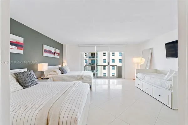 a spacious bedroom with a bed and a flat screen television