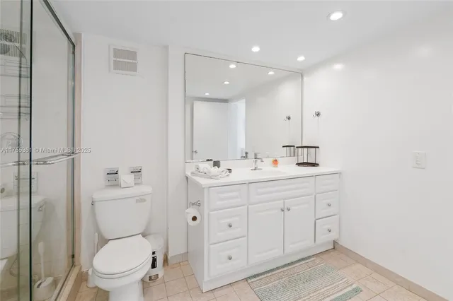 a bathroom with a toilet a sink a mirror and a shower