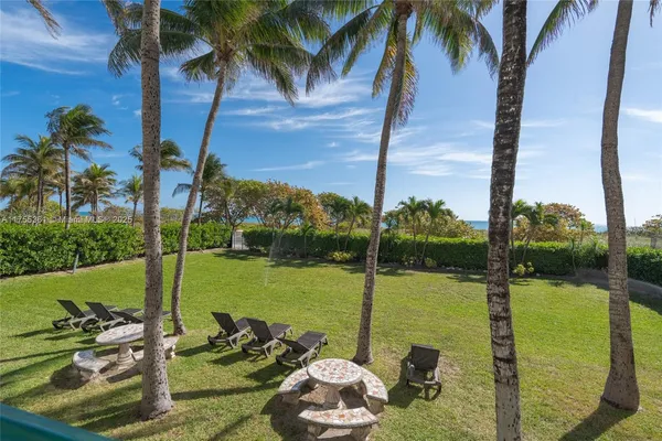 a view of a lake with a palm tree next to a yard
