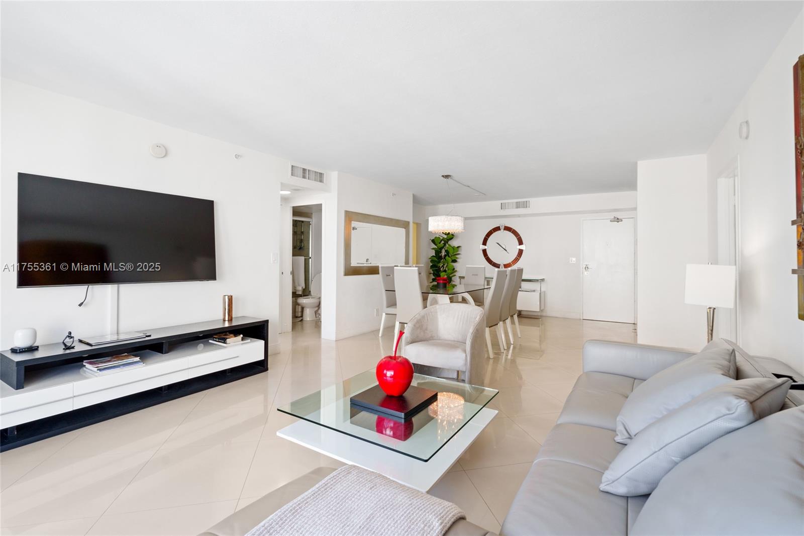 9195 Collins Avenue, Unit 1103 Surfside, FL 33154 - Photo 4 of 23 a living room with furniture and a flat screen tv