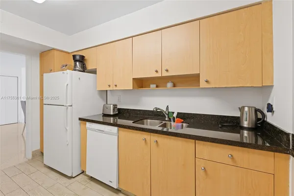 a kitchen with granite countertop cabinets and refrigerator