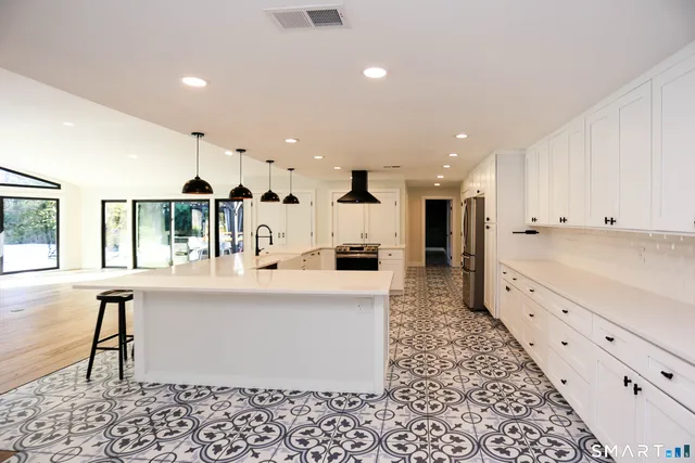 a large white kitchen with a large window