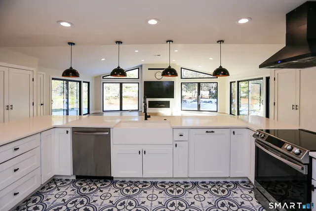 an open kitchen with stainless steel appliances kitchen island granite countertop a sink and a stove