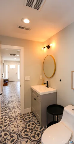 a bathroom with a sink toilet a mirror and vanity