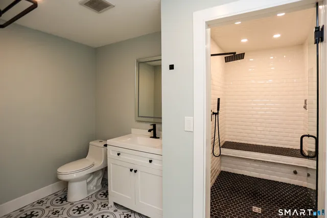 a bathroom with a toilet a sink and a mirror