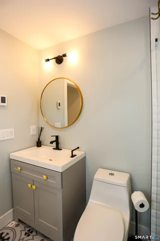 a bathroom with a sink a toilet and a mirror