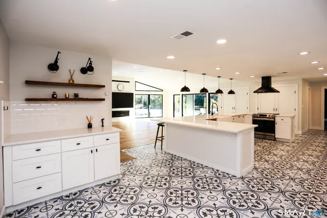 a kitchen with stainless steel appliances kitchen island granite countertop a sink and white cabinets