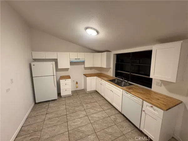 a kitchen with white cabinets and white appliances