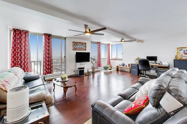 a living room with furniture kitchen view and a flat screen tv