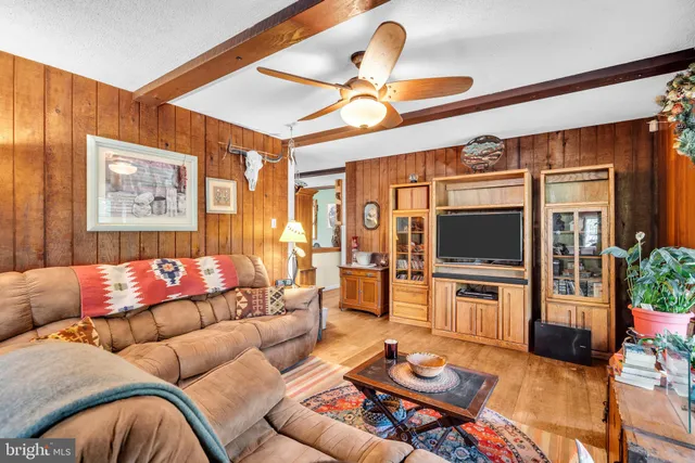 a living room with furniture a flat screen tv and a table