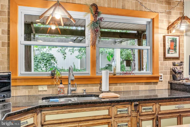 a open kitchen with stainless steel appliances granite countertop a stove top oven a sink dishwasher and white cabinets with wooden floor