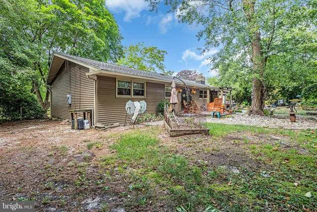 a backyard of a house with garden and outdoor seating