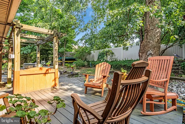 a view of a patio with table and chairs potted plants and large tree