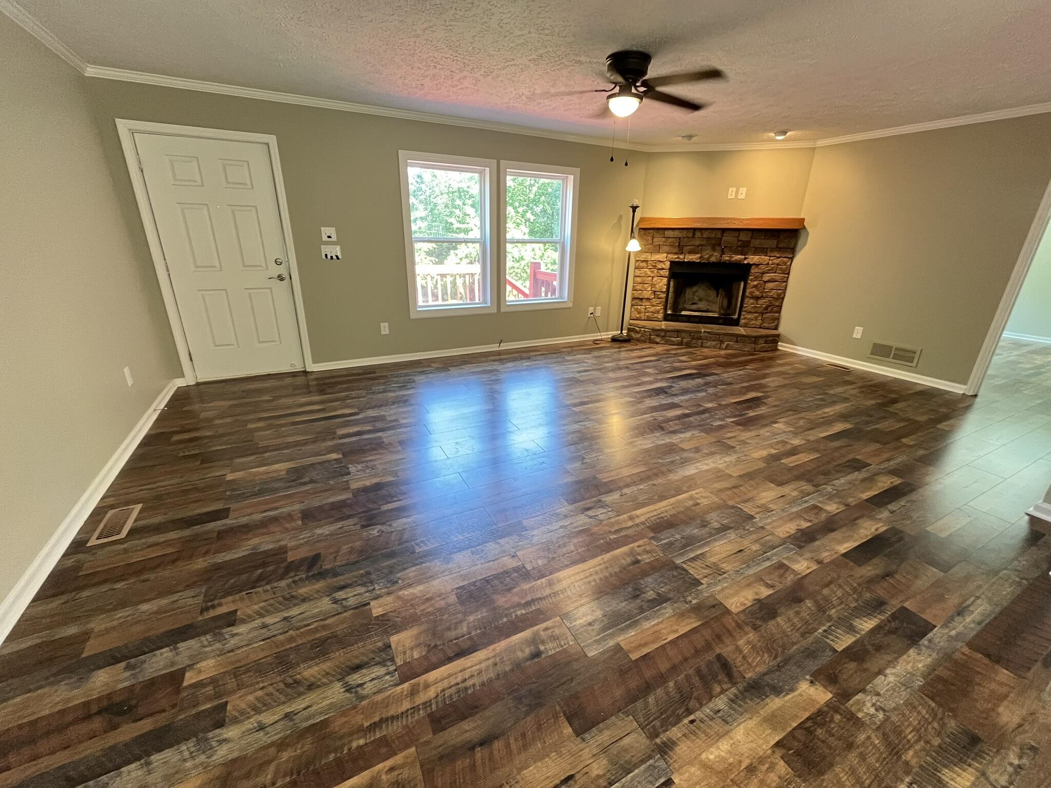 342 Monte Vista Road Union Hall, VA 24176 - Photo 4 of 26 wooden floor in an empty room with a fireplace and a window
