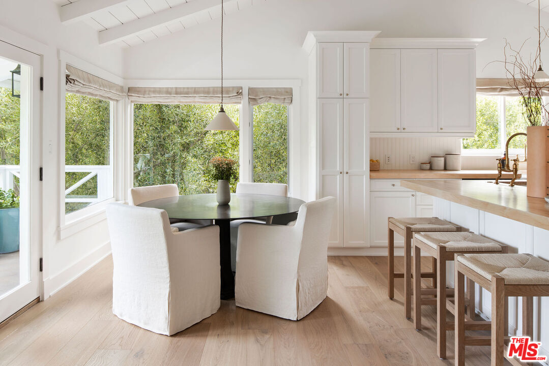 6456 Sycamore Meadows Drive Malibu, CA 90265 - Photo 13 of 34 a kitchen with stainless steel appliances granite countertop a stove top oven a sink a dining table and chairs