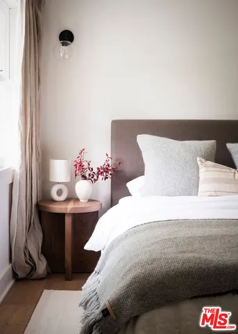 a bedroom with a bed and a potted plant
