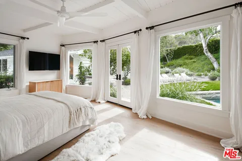 a bedroom with a large bed and a large window