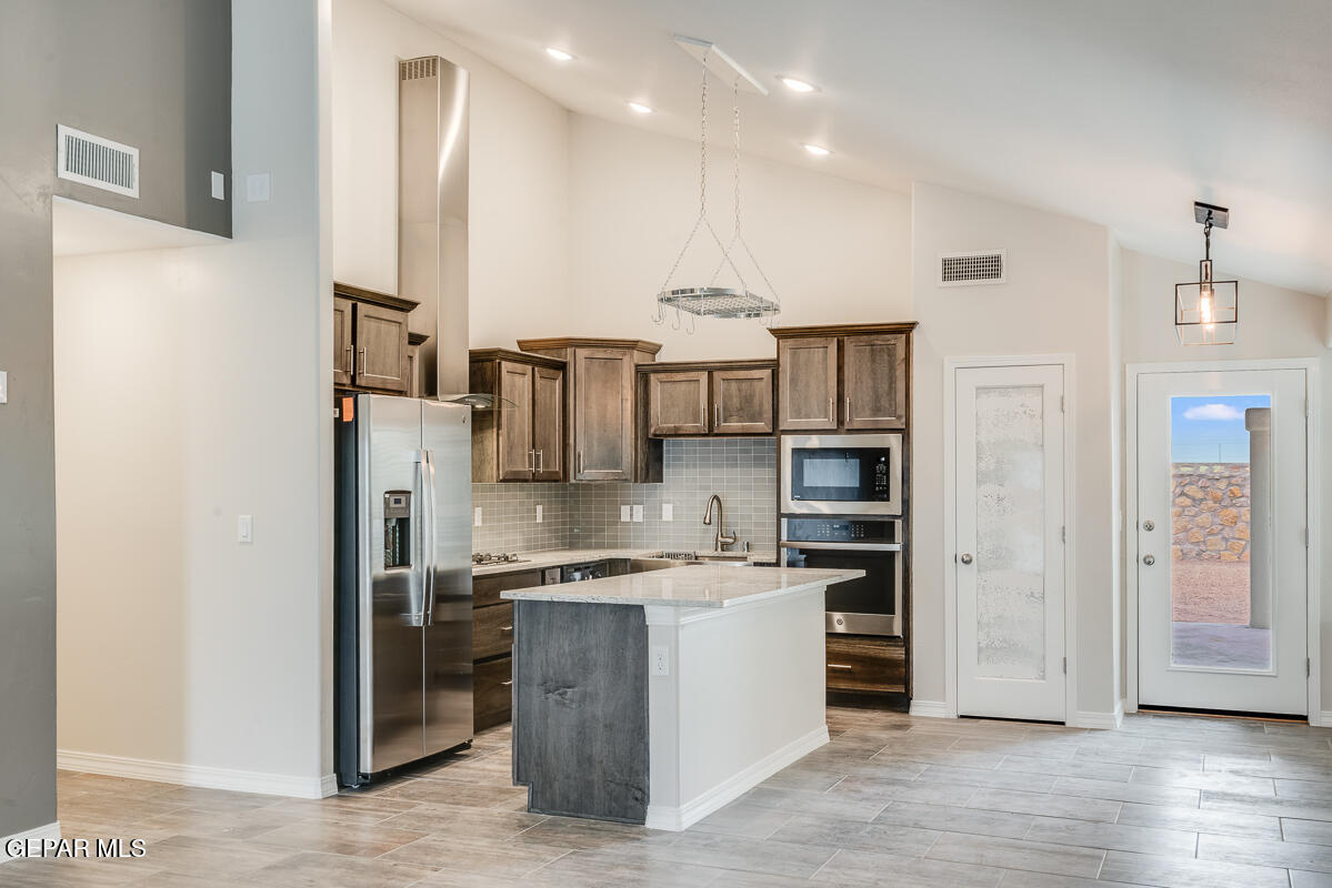 6048 Summer Ridge Santa Teresa, NM 88008 - Photo 5 of 21 a kitchen with stainless steel appliances kitchen island granite countertop a refrigerator and a sink