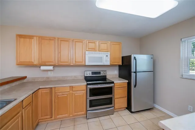 a kitchen with a refrigerator sink and cabinets