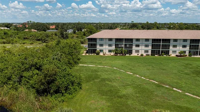 a view of a house with a big yard and large trees
