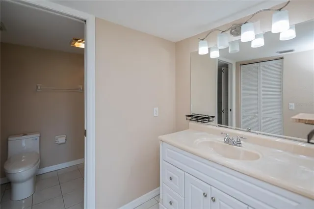 a bathroom with a sink a toilet and a large mirror